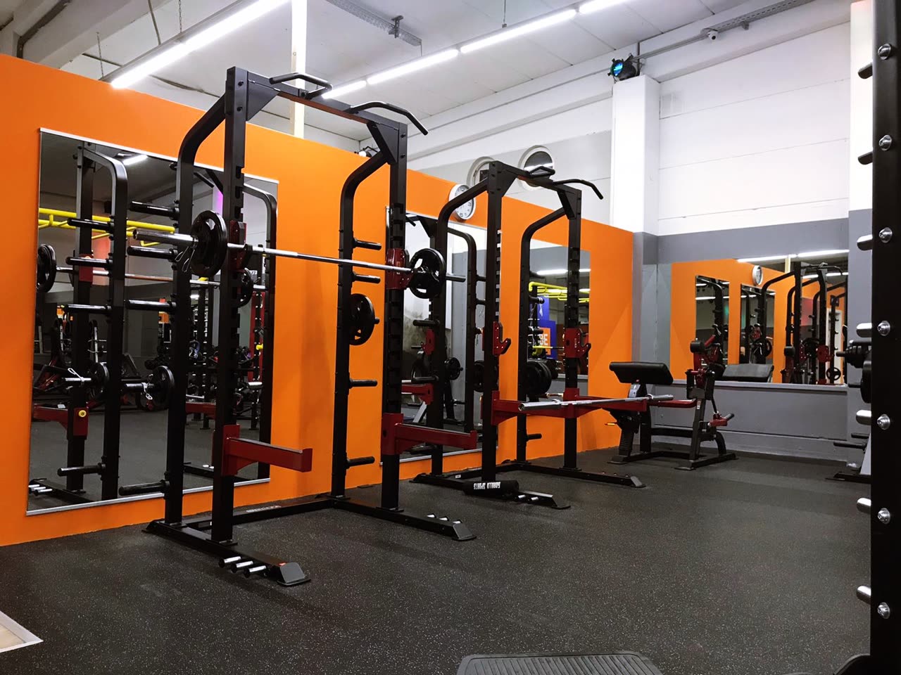 Power-Racks vor der orangen Spiegelwand